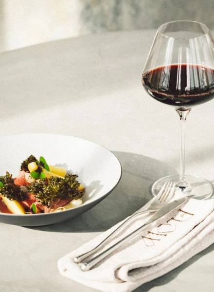 Elegant gedekte tafel met rode wijn en seizoensgerecht bij Flow Restaurant Lanaken