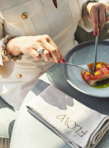 Gast geniet van een gerecht aan tafel met gebrandmerkt Flow Restaurant servet