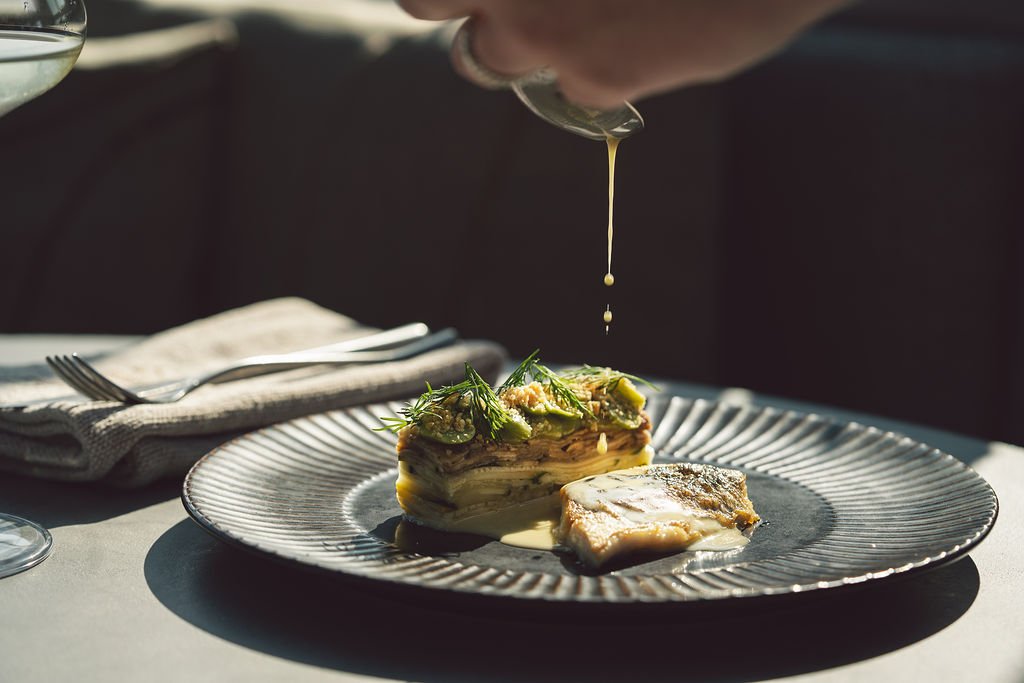 Interieurdetail met rode stoffen bekleding en marmeren tafelrand bij Flow Restaurant Lanaken