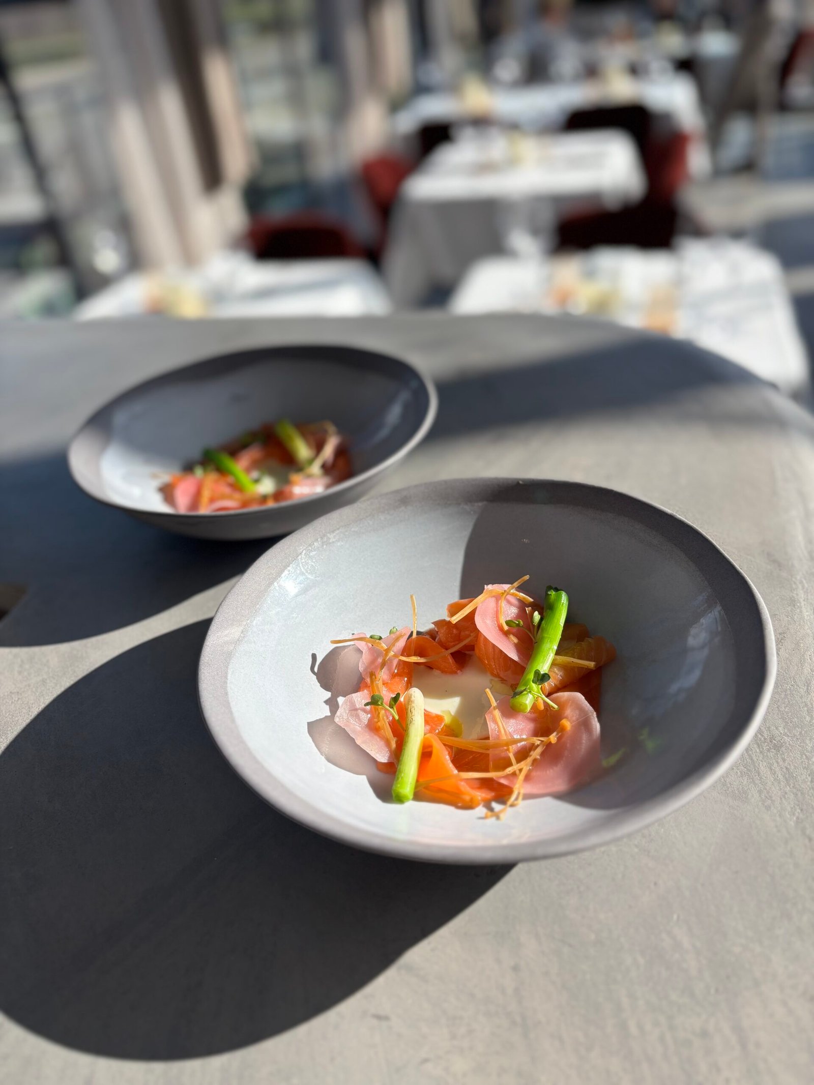 Bovenaanzicht van een donker geplateerd seizoensgerecht met cocktail bij Flow Restaurant Lanaken